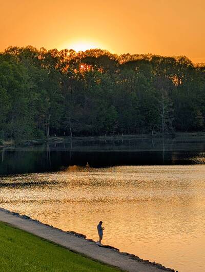 A man fishes during sunset at the Royal Lake in Fairfax.